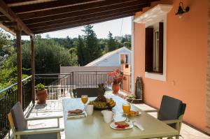 a table with food and drinks on a balcony at Villa Tettix (Τέττιξ) in Fiskardo