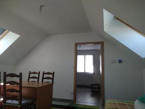 a room with an attic with a door and a table and chairs at Etape au Calme à 4Km du Center de Reims in Reims +14 photos