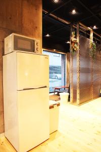a microwave on top of a refrigerator in a room at Kazemachigusa INN in Osaka