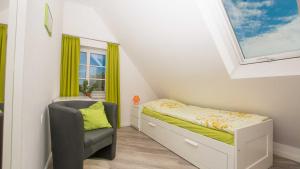 a small bedroom with a bed and a chair at Herta Kruse Ferienwohnungen in Jork