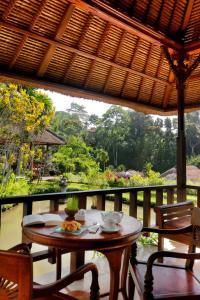 uma mesa e cadeiras numa varanda com vista em Santi Mandala Villa & Spa em Sukawati