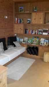 ein Wohnzimmer mit einem weißen Sofa und Bücherregalen in der Unterkunft Sieberlechnerhof in Lüsen