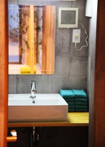a bathroom sink with a mirror and a window at Kazemachigusa INN in Osaka