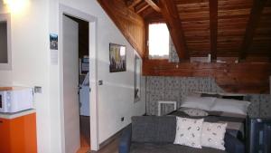 Dormitorio pequeño con cama y microondas en Lo Galetas - Alloggio ad uso turistico-VDA-AOSTA-n 0100, en Aosta