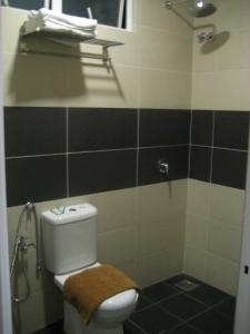 uma casa de banho com WC e azulejos pretos e brancos. em Festival Boutique Hotel em Kuala Lumpur