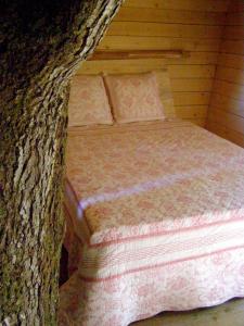 un letto in una baita con un albero di Les Ecolodges de l'Orbière a Forcé Altre 31 foto