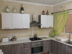 a kitchen with white cabinets and a stove top oven at Coral Reef Flat 7 in Marsalforn