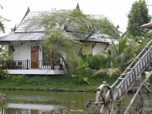 a house next to a river with a bridge at Baan Thai House in Phra Nakhon Si Ayutthaya