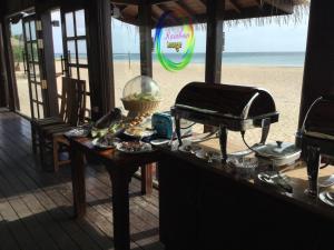 a buffet on a beach with the beach in the background at Nilaveli Beach Resort - Level 1 Certified in Nilaveli
