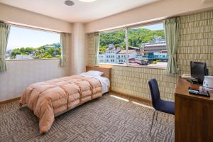 um quarto com uma cama, uma secretária e 2 janelas em Stay View Ikaho em Shibukawa