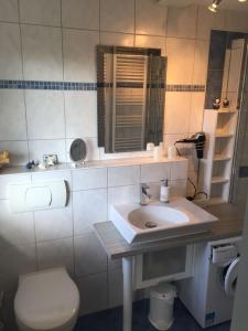 a bathroom with a sink and a toilet and a mirror at Am Ringwall 76 in Cuxhaven