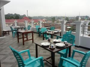 eine Terrasse mit Tischen und Stühlen auf dem Dach in der Unterkunft Toraja Lodge Hotel in Rantepao