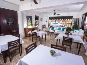B&M Setup Hotels في سانتو دومينغو: مطعم فيه طاولات وكراسي وفيه سيارة في الشباك