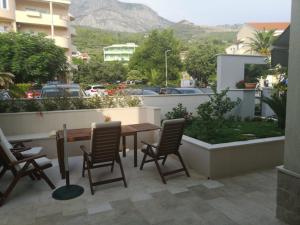 een patio met een tafel en stoelen op een balkon bij Apartments Ivandić in Tučepi