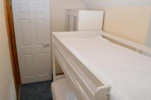 a small bedroom with two bunk beds and a door at Flat 14c Bayhead in Stornoway