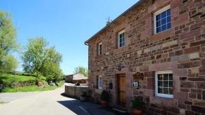 a large brick building with a door on the side at Casa Rural LA COVA in Suano