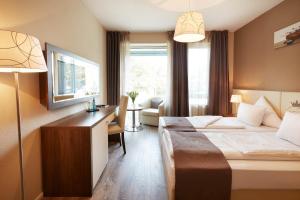 ミュンヘンにあるEmpress Boutique Hotelのベッドとデスクが備わるホテルルームです。