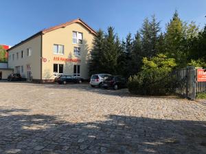 ein Gebäude mit Autos auf einem Parkplatz in der Unterkunft A10 Apartmenthaus in Rangsdorf