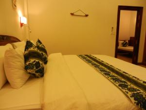 Un dormitorio con una cama con almohadas. en Eureka Villas Siem Reap en Siem Riep