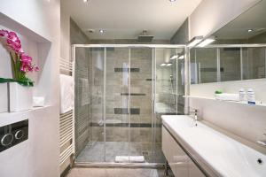 a bathroom with a shower with a tub and a sink at "Le Nomad" by EnjoyNice, luxury central apartment with airco in Nice