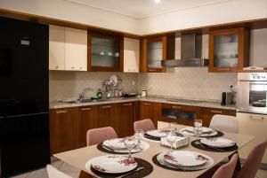 a kitchen with a table with plates and wine glasses at Luxury seaview apartment by the sea in Saronida