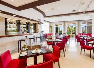 un ristorante con sedie e tavoli rossi e un bar di Exe Las Adelfas a Cordoba