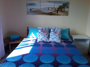 a bedroom with a bed with blue and blue pillows at Chez Cozy's in Albion +25 photos