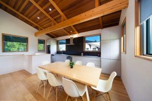 a kitchen and dining room with a wooden table and chairs at Wagaya Chalet by Hakuba Hospitality Group in Hakuba