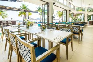 長灘島的住宿－長灘島探索海灘度假村，餐厅设有白色的桌子和蓝色的椅子