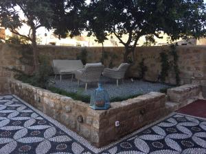 a garden with chairs and a table and trees at Tafros Villa in Rhodes Town