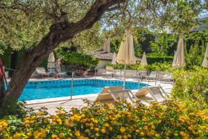 a swimming pool with chairs and umbrellas at Villa Daphne in Giardini Naxos