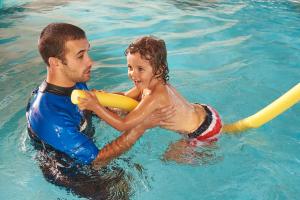 a man and a young girl playing in the swimming pool at Martinhal Sagres Beach Family Resort Hotel in Sagres