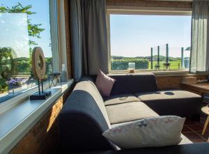 a living room with a couch and a large window at Zoet & Zout in Zoutelande