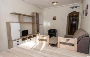 Elle comprend un petit salon avec une table et une télévision. dans l'établissement Apartamentos Turísticos Fresno, à Torrevieja