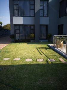 a grassy yard in front of a building at Mmakgabo Boutique Lodge in Bela-Bela