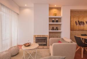 a living room with a couch and a fireplace at Casa Braites T3 Soltroia Mar - Ar Condicionado - 5 minutos a pé da praia e a 12Km da Comporta in Troia