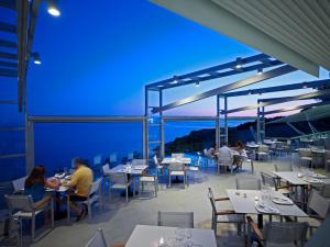 people sitting at tables on the roof of a restaurant at Adrina Resort & Spa in Panormos Skopelos