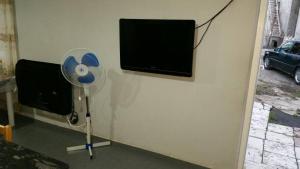 a room with a fan and a flat screen tv at Hotel Ergo in Batumi
