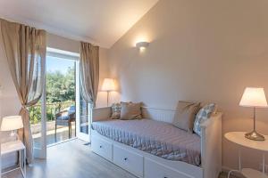 a white bedroom with a bed and a balcony at Torre S.Antonio in Santa Caterina dello Ionio