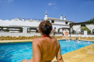 una mujer en bikini sentada junto a una piscina en Cuevas El Moral, en Castilléjar