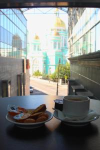 a cup of coffee and a plate of cookies on a table at Hotel Elokhovsky City in Moscow