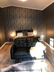 um sofá de couro preto num quarto com uma cama em Amande Bed and Breakfast em McLaren Vale
