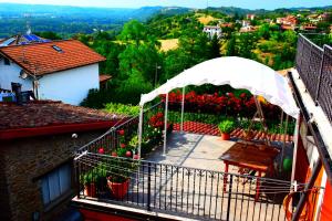 a balcony with a table and a white canopy at B&B Il Borgo Fiorito in Lerma