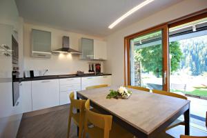 a kitchen and dining room with a wooden table and chairs at casa waldner in Castello di Fiemme