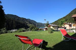 two red chairs sitting in a field of grass at casa waldner in Castello di Fiemme