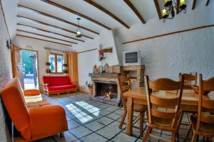 Una sala de estar con una mesa y una chimenea. en Cuevas El Moral, en Castilléjar