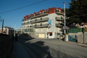 a person walking down a street in front of a building at Hostal Gabino in Isla