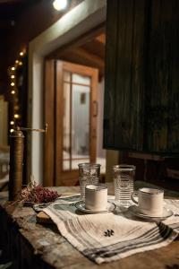 una mesa con dos tazas y platos en ella en Small Guesthouse In The Garden, en Amarinto