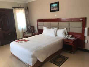 sypialnia z dużym łóżkiem i telefonem na stole w obiekcie Northern Rock Hotel w mieście Mpika