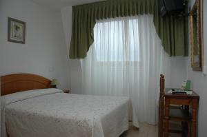 a bedroom with a bed and a large window at Hostal Gabino in Isla +6 photos